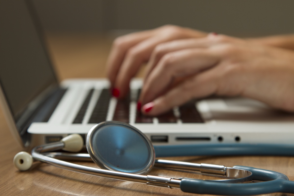 Stethoscope resting on a laptop computer